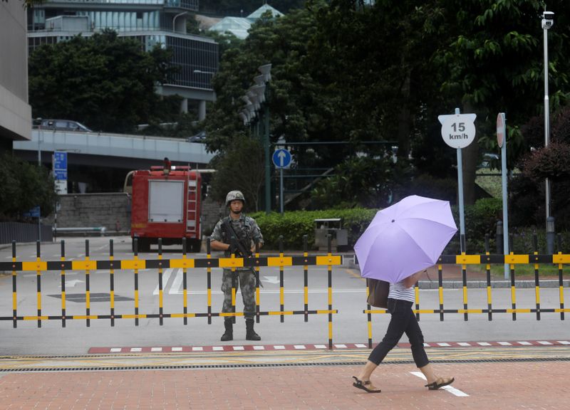 FILE PHOTO:  A Chinese People's Liberation Army (PLA) soldier guards the entrance to the PLA Hong Kong Garrison headquarters in the Central Business District in Hong Kong, China, August 29, 2019. REUTERS/Anushree Fadnavis