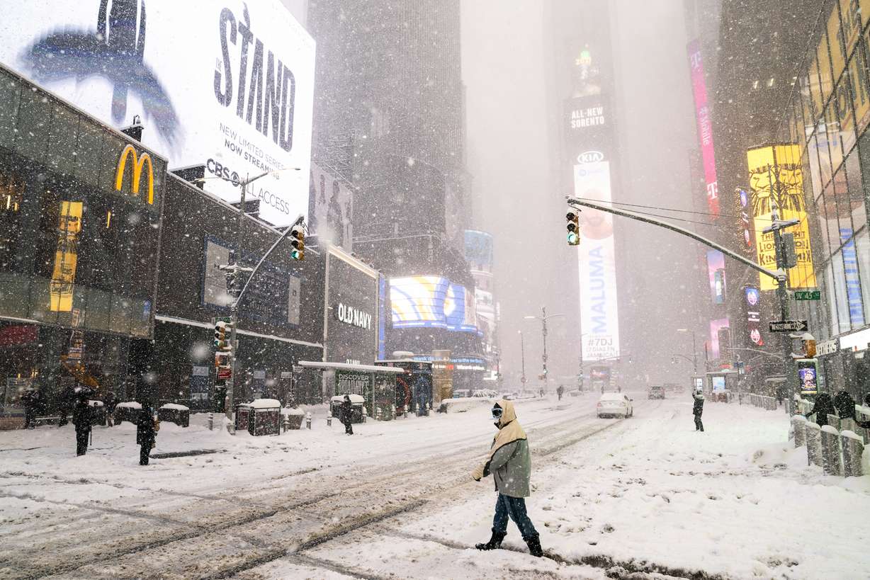 Pedestrians make their way through Times Square during a snowstorm, Monday, Feb. 1, 2021, in the Manhattan borough of New York.