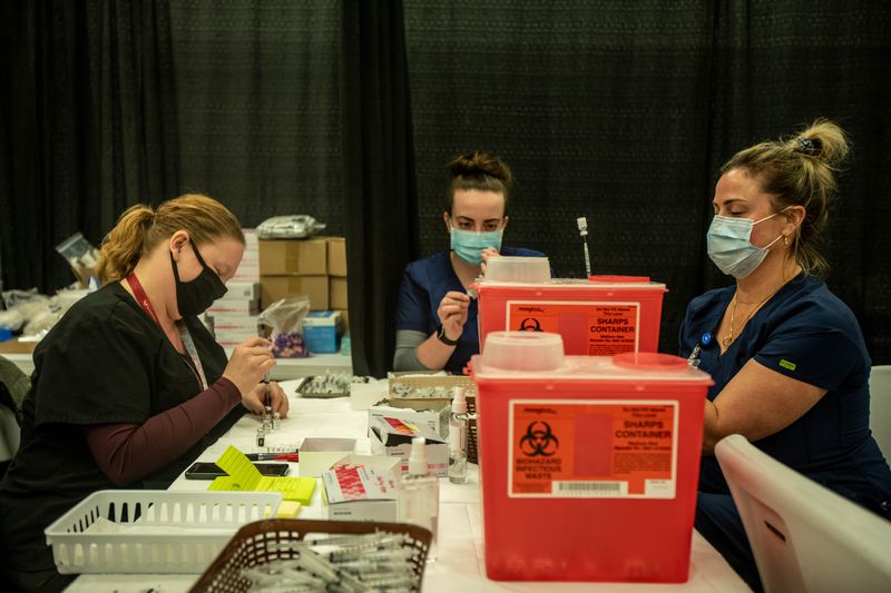 Mandy Chamberlain, left, Kaitlyn Ulibarri, center, and
Cindy Mason, right, prepare COVID-19 vaccines at a vaccination
clinic in Spanish Fork on Monday, Feb. 1, 2021.