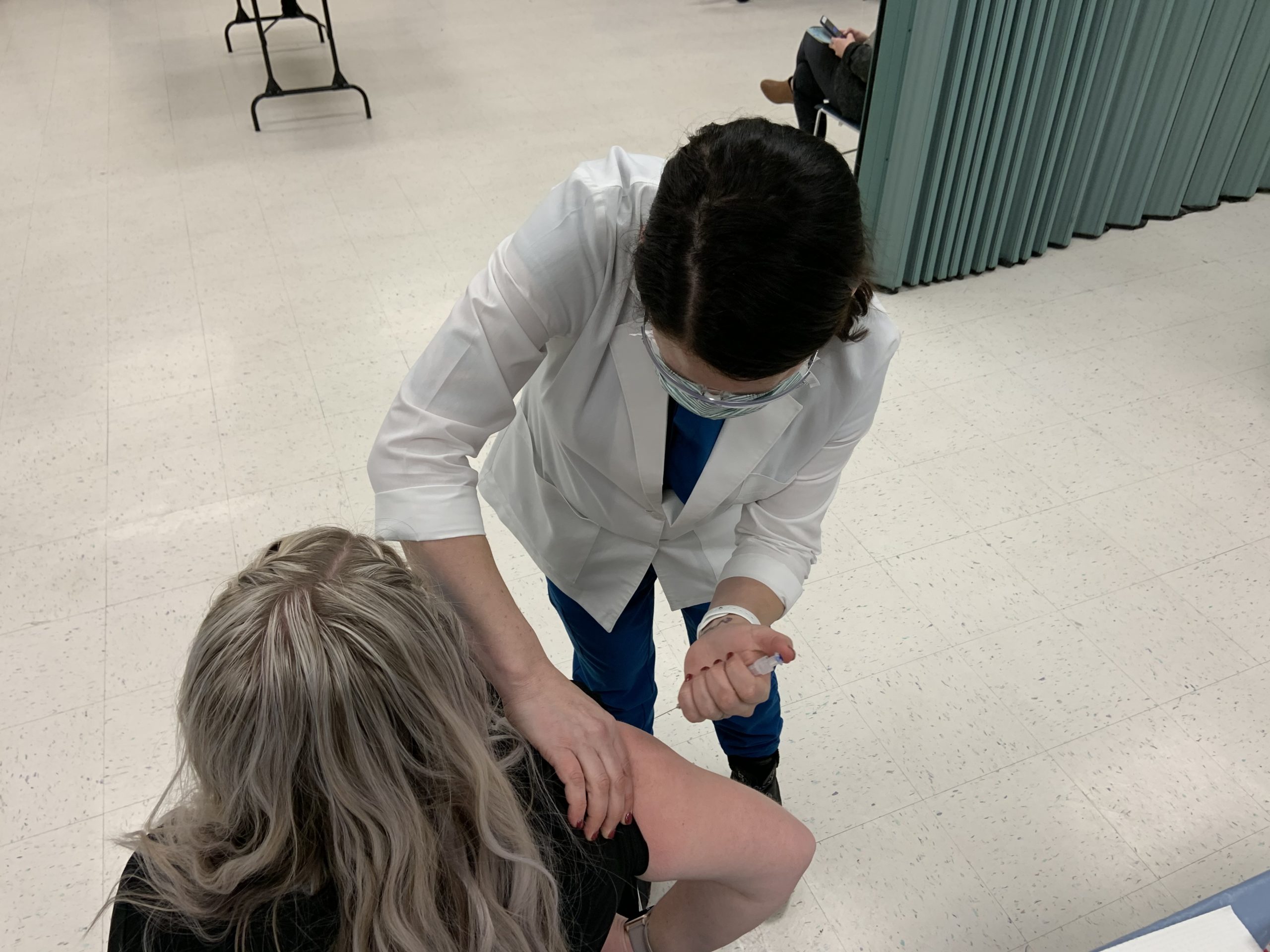 Taelor Leonelli, RN, administers a COVID-19 vaccine at the Tooele County Health Department building.