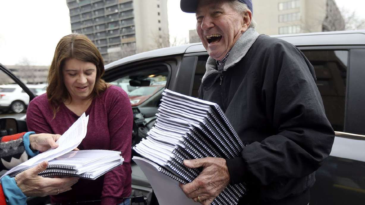 Kent Jorgenson, right, collects packets of signatures
for the Utah tax referendum from Kimberly Bekmezian outside of the
Salt Lake County Government Center in Salt Lake City in this Jan.
21, 2020, file photo.