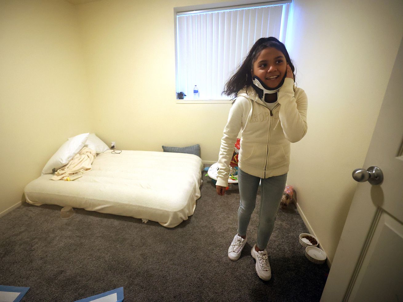 Jennifer Ramirez, 10, walks out of a room in the
apartment she shares with her mother, Juana Segura, and sister,
Citlalli Ramirez, 14, in South Salt Lake on Friday, Feb. 5, 2021.
Jennifer was injured on Jan. 22, when a Hyundai sedan crashed
through her basement apartment. The family is struggling after
being displaced.