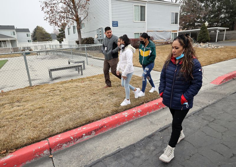 Danial Hernandez, a victim advocate, left, walks with
sisters Jennifer Ramirez 10, and Citlalli Ramirez 14, and the
girls’ mother, Juana Segura, outside of their old apartment in
South Salt Lake on Friday, Feb. 5, 2021. The family was displaced
after a Hyundai sedan crashed into it on Jan. 22, injuring
Jennifer.