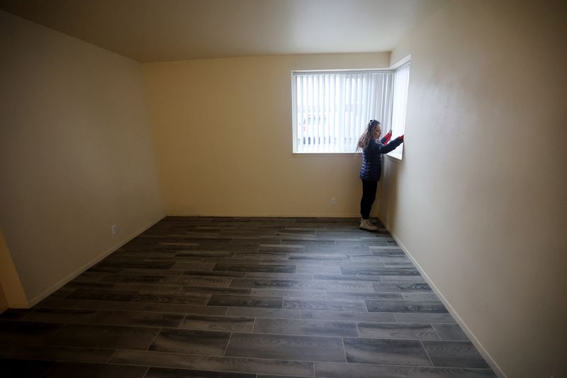 Juana Segura opens the blinds in the South Salt Lake
apartment she and her daughters, Citlalli Ramirez, 14, Jennifer
Ramirez, 10, are temporarily living in on Friday, Feb. 5, 2021. The
three were displaced after a Hyundai sedan crashed into it on Jan.
22, injuring Jennifer.