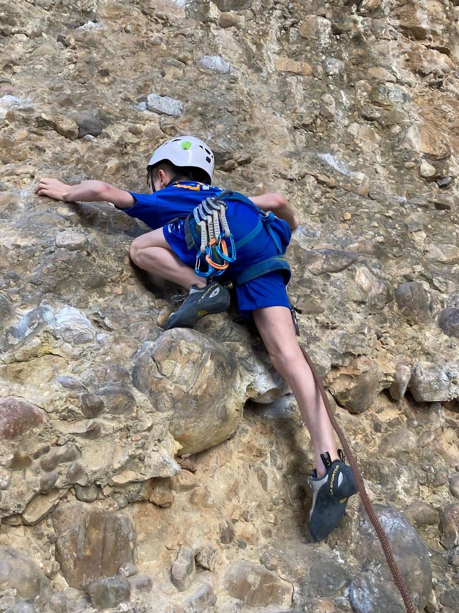Conner Bailey climbs on an outdoor rock wall.