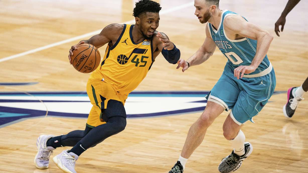 Utah Jazz guard Donovan Mitchell (45) drives to the basket while guarded by Charlotte Hornets forward Gordon Hayward (20) during the second half of an NBA basketball game in Charlotte, N.C., Friday, Feb. 5, 2021. The Jazz won 138-121. (AP Photo/Jacob Kupferman)