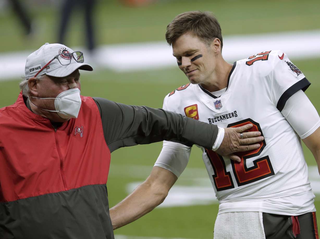 In this Jan. 17, 2021, file photo, Tampa Bay Buccaneers coach Bruce Arians, left, speaks with quarterback Tom Brady before the team's NFL divisional round playoff football game against the New Orleans Saints in New Orleans. Both Andy Reid and Arians are considered players’ coaches, though they do it in different ways. It's a quality that’s helped them reach the Super Bowl.
