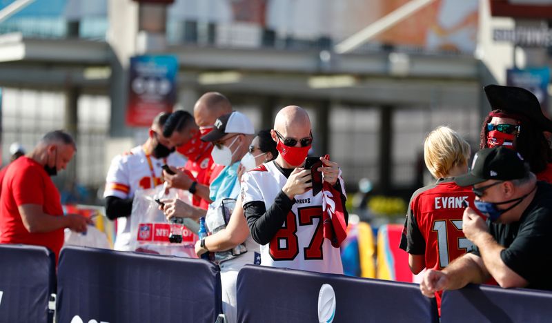 Feb 7, 2020; Tampa, FL, USA;  Fans check their cellular phones outside Raymond James Stadium before Super Bowl LV between the Kansas City Chiefs and the Tampa Bay Buccaneers.  Mandatory Credit: Kim Klement-USA TODAY Sports