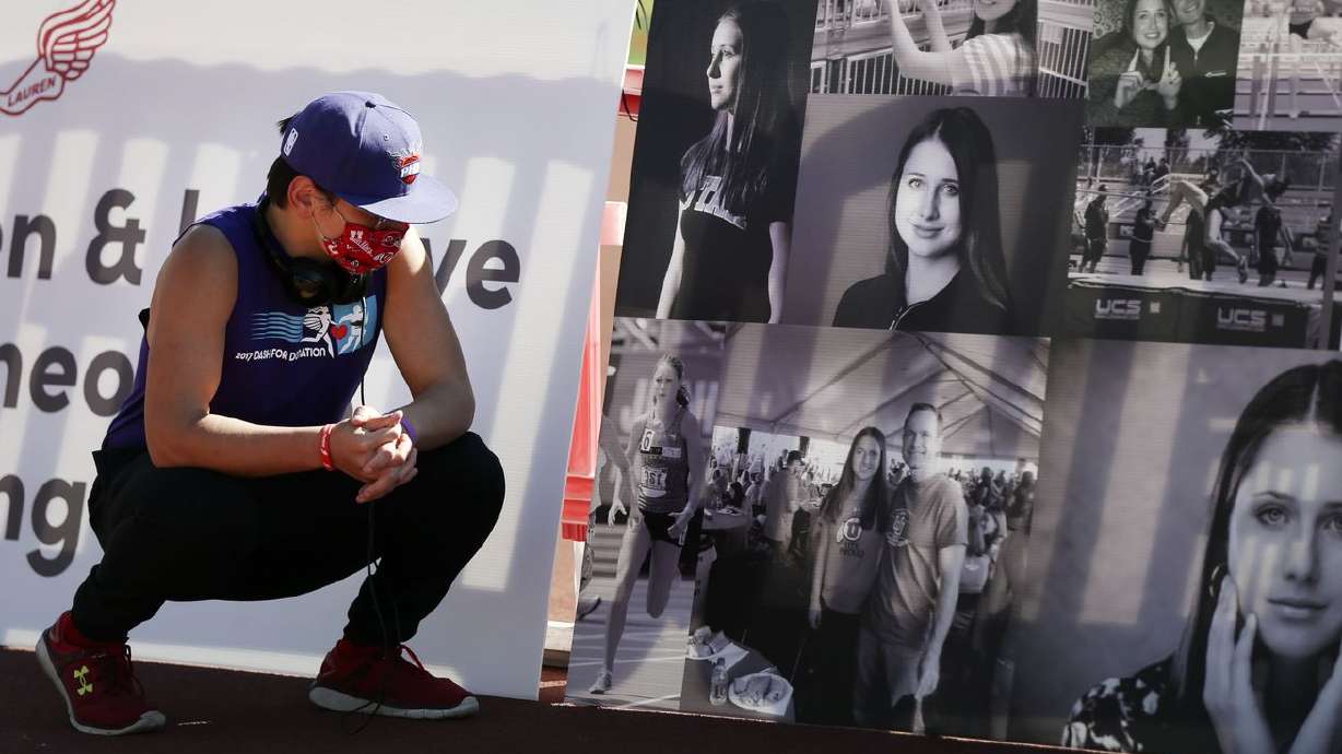 Tastan Sperling, a friend of slain University of Utah
student Lauren McCluskey, looks at photos of her during the Lauren
McCluskey Memorial Walk at the McCarthey Family Track and Field
Complex on the University of Utah campus in Salt Lake City on
Thursday, Oct. 22, 2020. McCluskey, a track athlete, was was shot
and killed near her dorm by Melvin Shawn Rowland, 37, on Oct. 22,
2018,