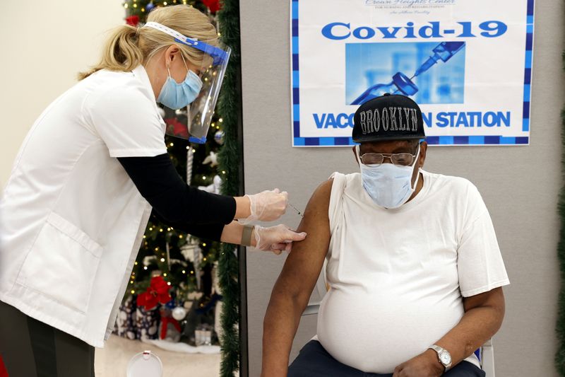 FILE PHOTO: George Valley, a patient at Crown Heights Center for Nursing and Rehabilitation, a nursing home facility, receives the Pfizer-BioNTech coronavirus disease (COVID-19) vaccine from Walgreens Pharmacist Annette Marshall, in Brooklyn, New York, U.S., December 22, 2020. REUTERS/Yuki Iwamura/File Photo