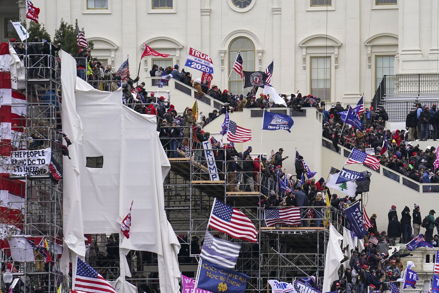 In this Jan. 6, 2021, file photo rioters loyal to President Donald Trump storm the U.S. Capitol in Washington. Arguments begin Tuesday, Feb. 9, in the impeachment trial of Donald Trump on allegations that he incited the violent mob that stormed the U.S. Capitol on Jan. 6.
