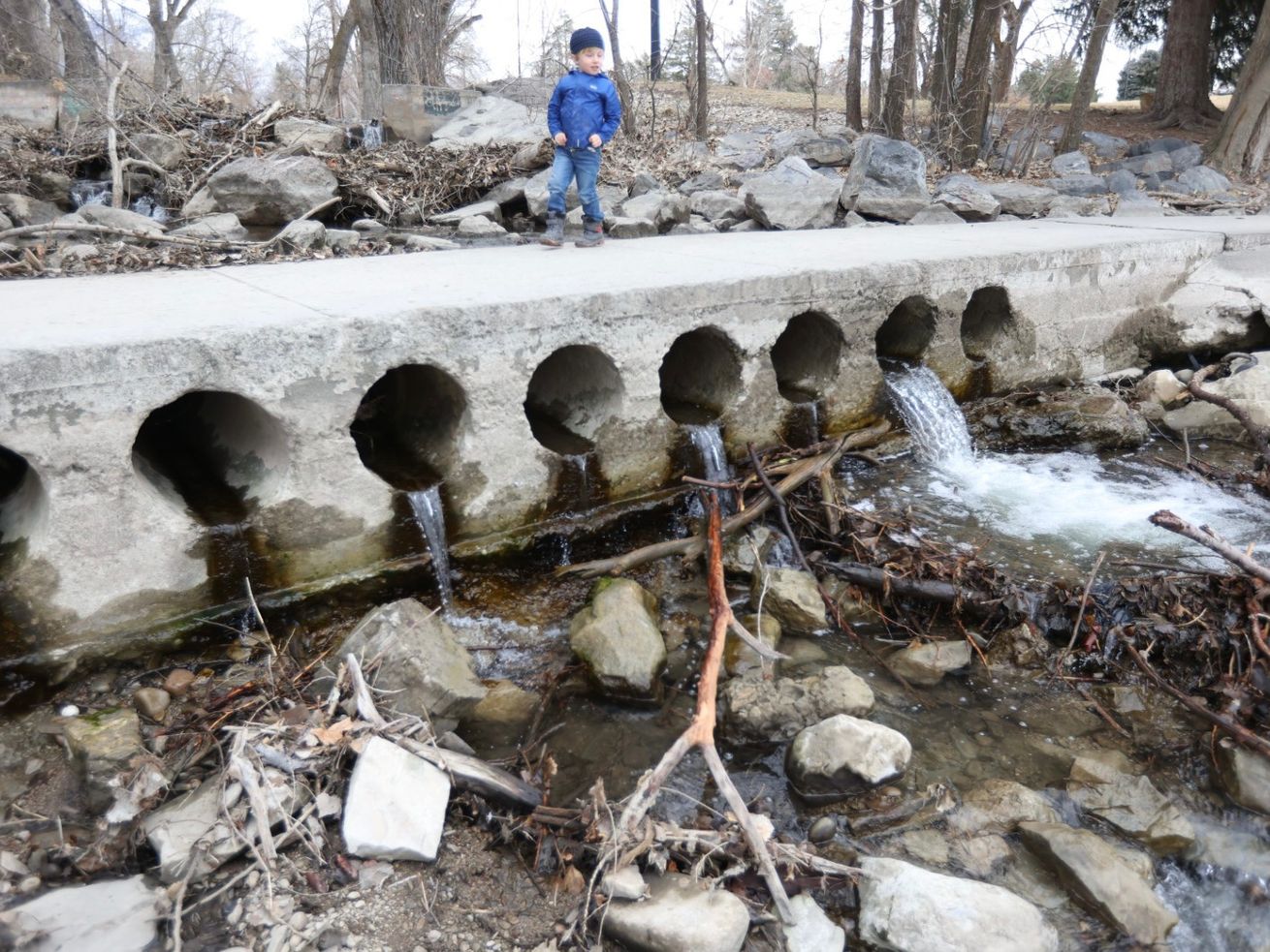 Henry Hovey, 4, stands on a culvert in Sugar House Park
as water from Parleys Creek trickles from it on Tuesday, Feb. 9,
2021.