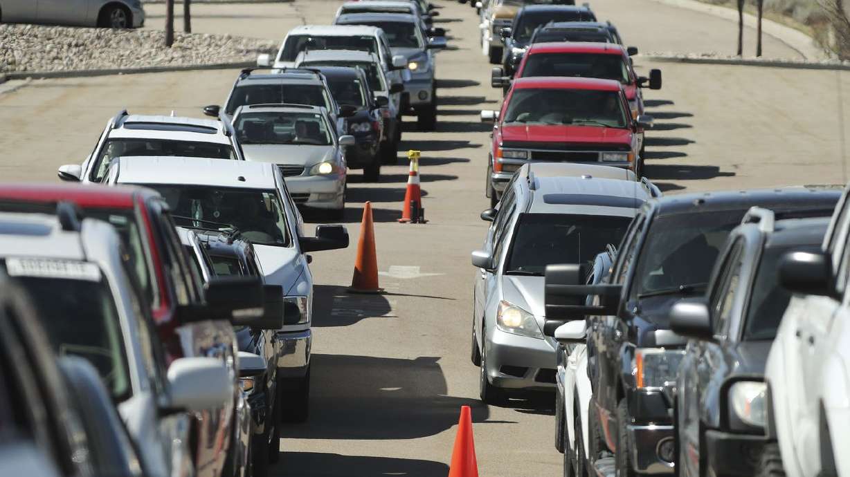 Hundreds of cars wait in line at the Division of
Motor Vehicles drive-thru window in Draper on Friday, April 3,
2020. Some waited in line for hours.