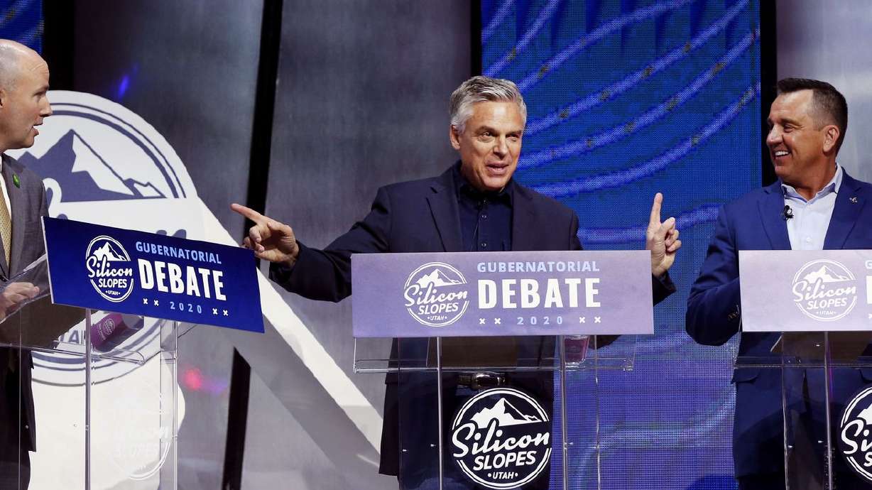 Former Utah Gov. Jon Huntsman Jr., center, jokes about
getting caught in the middle of a debate between then-Lt. Gov.
Spencer Cox, left, and former Utah House Speaker Greg Hughes during
a gubernatorial debate at the Silicon Slopes Tech Summit at the
Salt Palace Convention Center in Salt Lake City on Friday, Jan. 31,
2020. The Utah Legislature is considering limits on "party-hopping”
before primaries after many voters switched parties to vote in the
2020 gubernatorial primary.