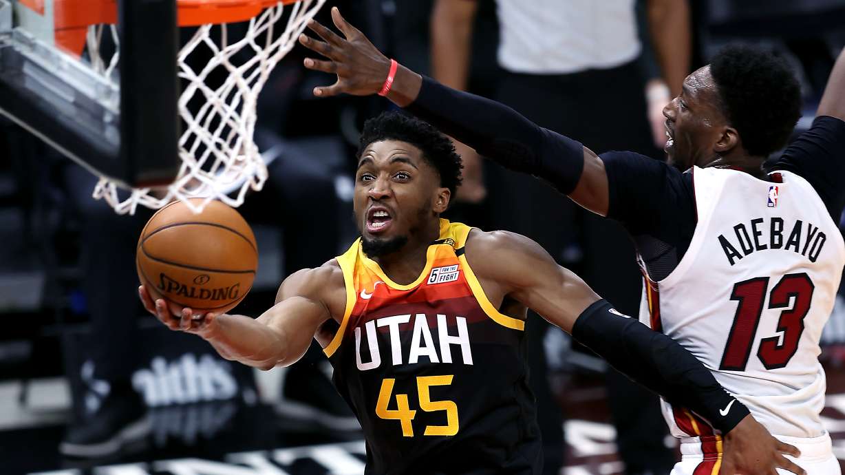 Utah Jazz guard Donovan Mitchell (45) goes around Miami Heat center Bam Adebayo (13) for a lay up as the Utah Jazz and the Miami Heat play an NBA basketball game at Vivint Smart Home Arena in Salt Lake City on Saturday, Feb. 13, 2021.