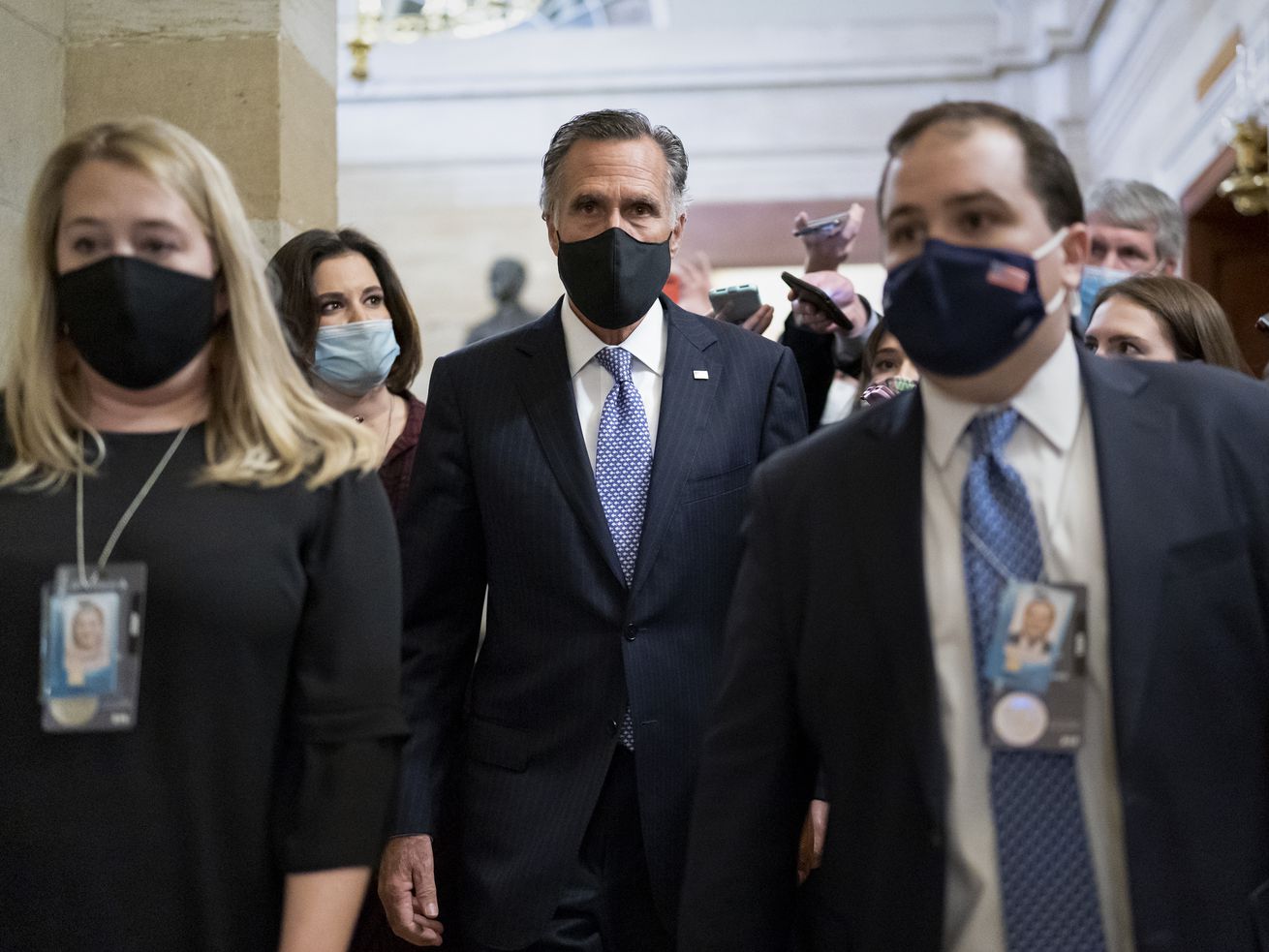 Sen. Mitt Romney, R-Utah, is flanked by his staff with
reporters following a break in former President Donald Trump’s
impeachment trial, at the Capitol in Washington, Wednesday, Feb.
10, 2021.