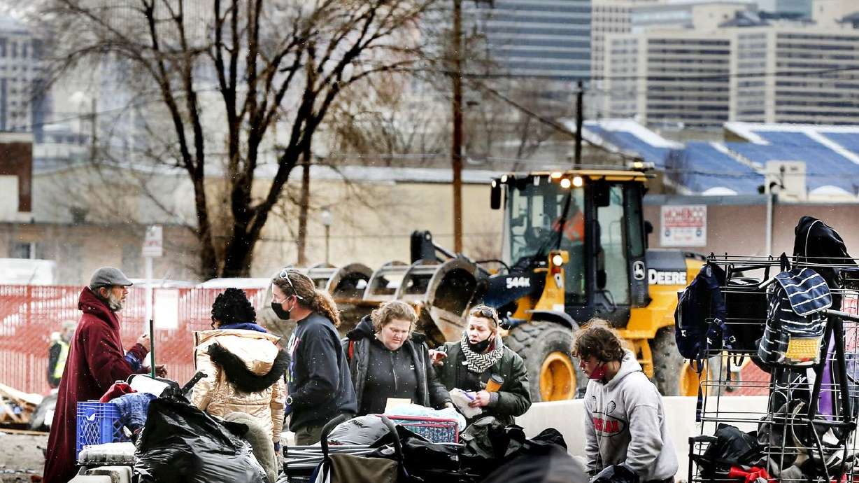 Volunteers and homeless people sort through their
belongings as the Salt Lake County Health Department clears out
Camp Last Hope in Salt Lake City on Thursday, Feb. 4, 2021.