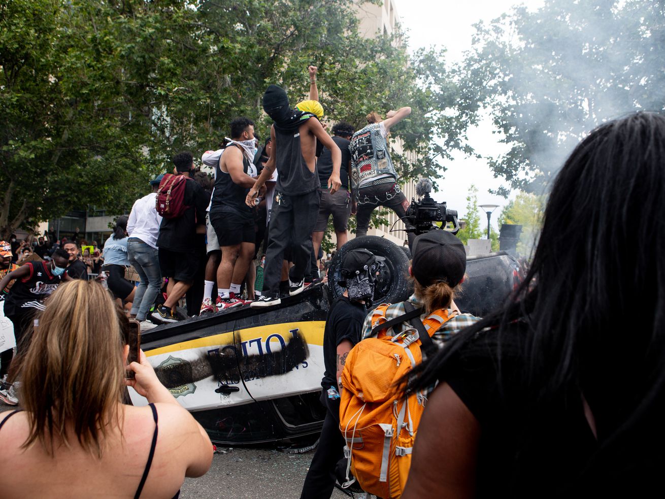 People jump on top of an overturned police car as they
protest police brutality in Salt Lake City on Saturday, May 30,
2020.