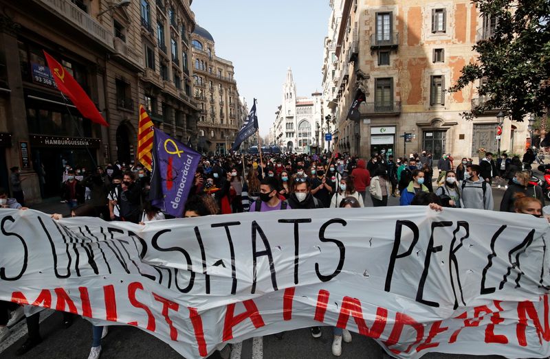 Demonstrators hold a banner during a protest in support of Catalan rapper Pablo Hasel, after he was given a jail sentence on charges of glorifying terrorism and insulting royalty in his songs, in Barcelona, Spain, February 19, 2021. REUTERS/Albert Gea