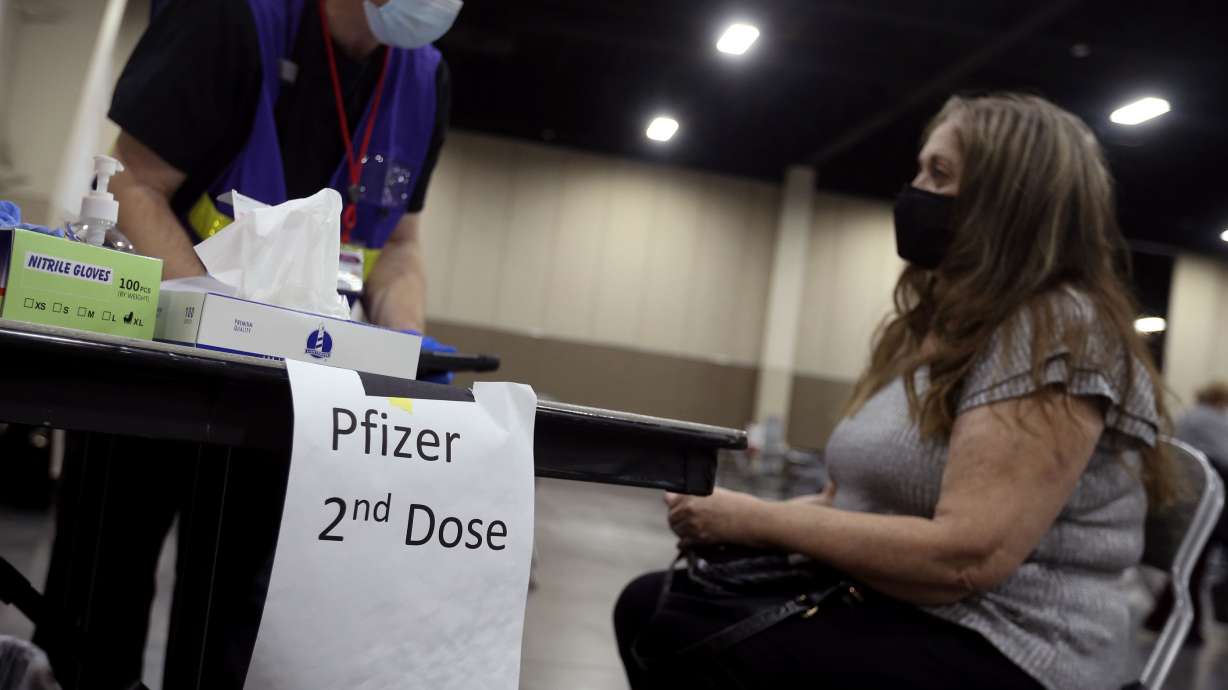 Jonathan Pimble, left, speaks with Venice Carlson, of Murray, before administering a COVID-19 vaccination at the Mountain America Exposition Center in Sandy on Thursday, Feb. 11, 2021.