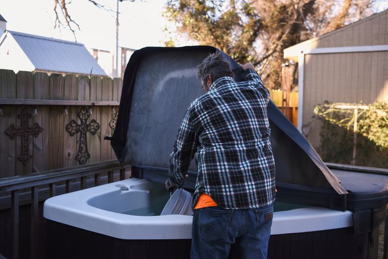 FILE PHOTO: Jay Farrell gathers water from his hot tub so that he can flush his family’s toilet as people across the city find themselves without running water after pipes ruptured due to freezing temperatures following an unprecedented winter storm in Houston, Texas, U.S., February 19, 2021.  REUTERS/Callaghan O'Hare/File Photo