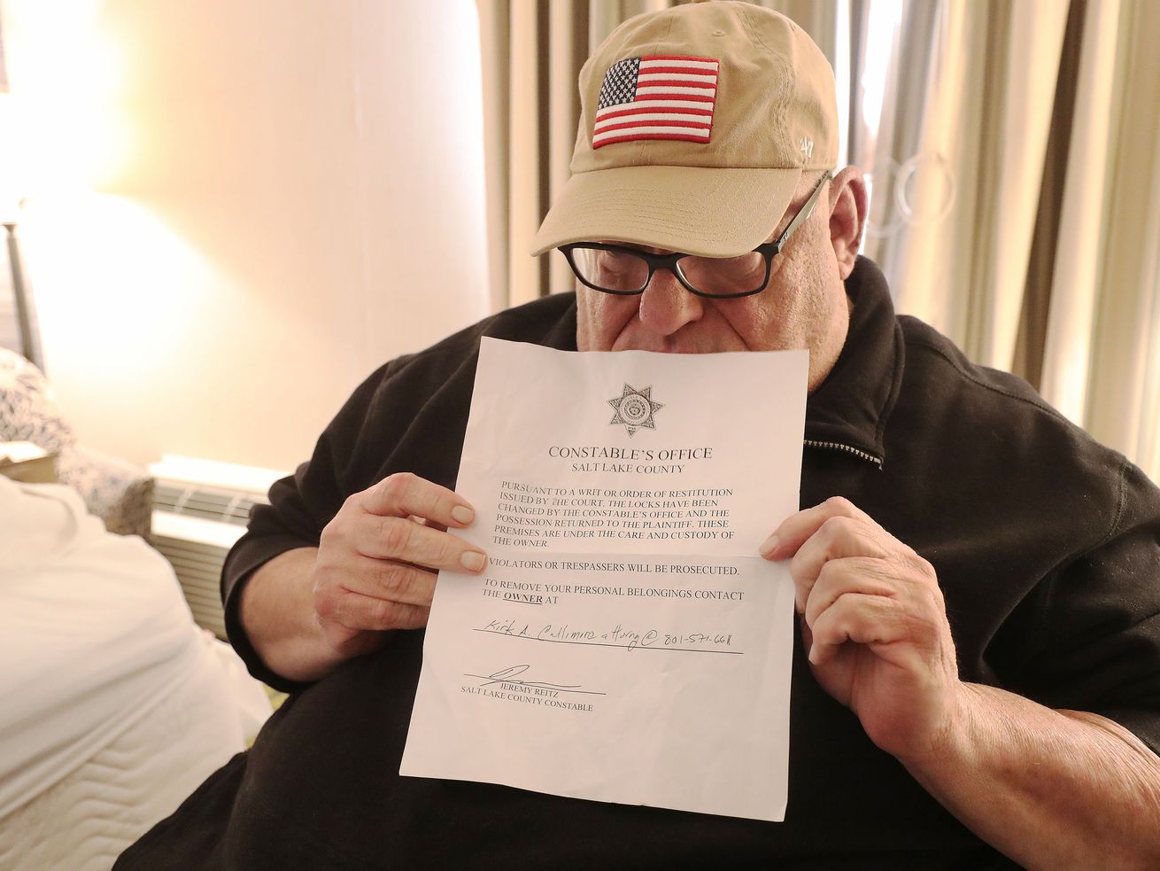 Doug Henderson holds an eviction notice in his and his
wife’s room at the Salt Lake Plaza Hotel Temple Square in Salt Lake
City on Friday, Jan. 15, 2021. The Hendersons were evicted
from their apartment earlier in the week.