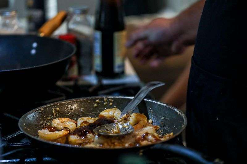 Nathan Savaiinaea, an owner of SaWrap, a
microenterprise home kitchen, prepares food to sell in Provo on
Thursday, Feb. 18, 2021.