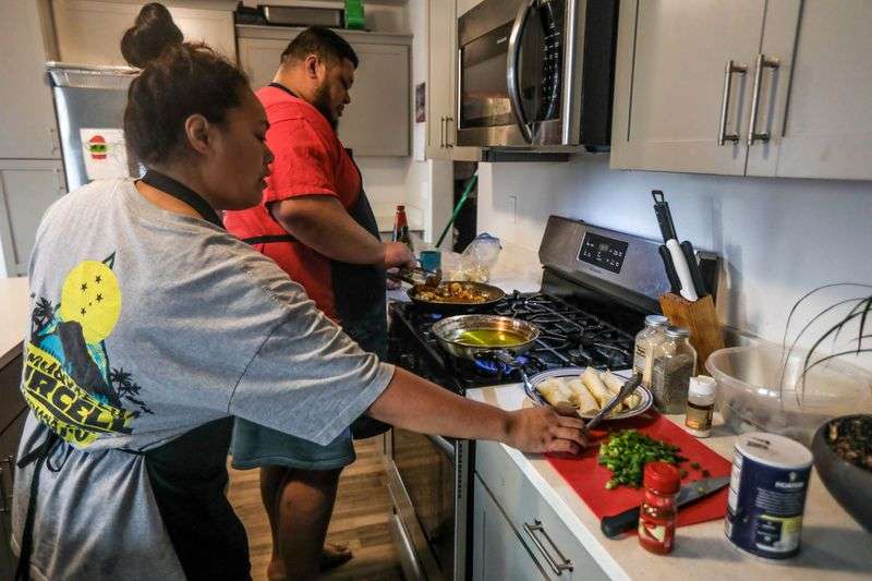 Lola Savaiinaea, left, and Nathan Savaiinaea, right,
owners of SaWrap, a microenterprise home kitchen, prepare food to
sell in Provo on Thursday, Feb. 18, 2021.