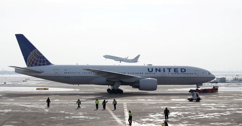 FILE PHOTO: A United Airlines Boeing 777-200ER  plane is towed as an American Airlines Boeing 737 plane departs from O'Hare International Airport in Chicago, Illinois, U.S. Nov. 30, 2018. REUTERS/Kamil Krzaczynski/File Photo
