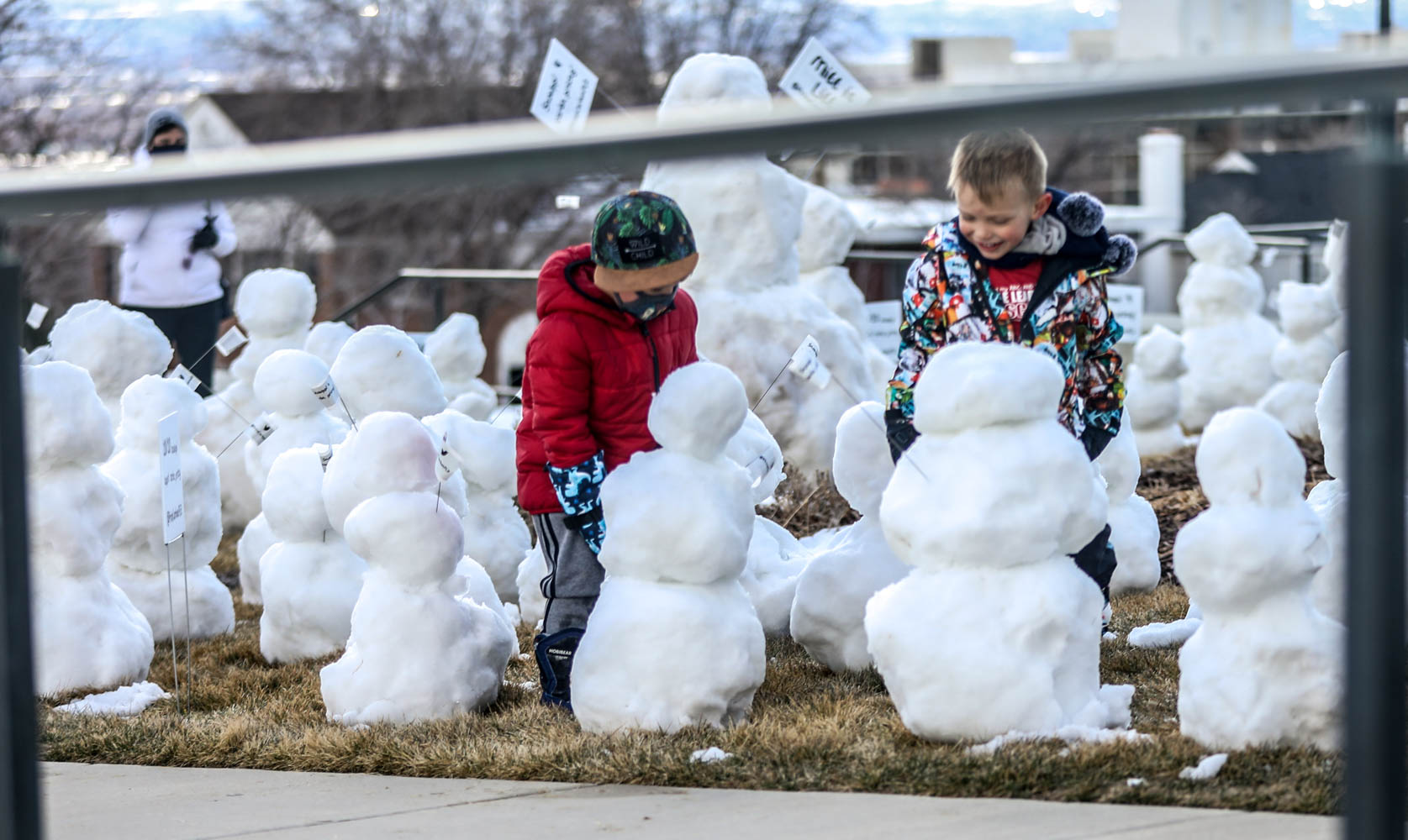 Children play among snowmen at the state Capitol in Salt Lake City on Sunday, Feb. 21, 2021. Many among the large group of snowmen held signs demanding a price on carbon to save their endangered species.