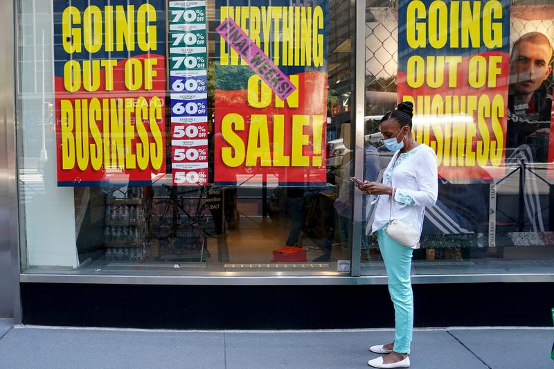 FILE PHOTO: People walk past a business that is closing following the outbreak of the coronavirus disease (COVID-19) in the Manhattan borough of New York City, New York, U.S., August 17, 2020. REUTERS/Carlo Allegri//File Photo