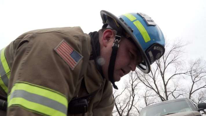 Firefighter EMT Tyson Astin rolls up a hose after completing some training.