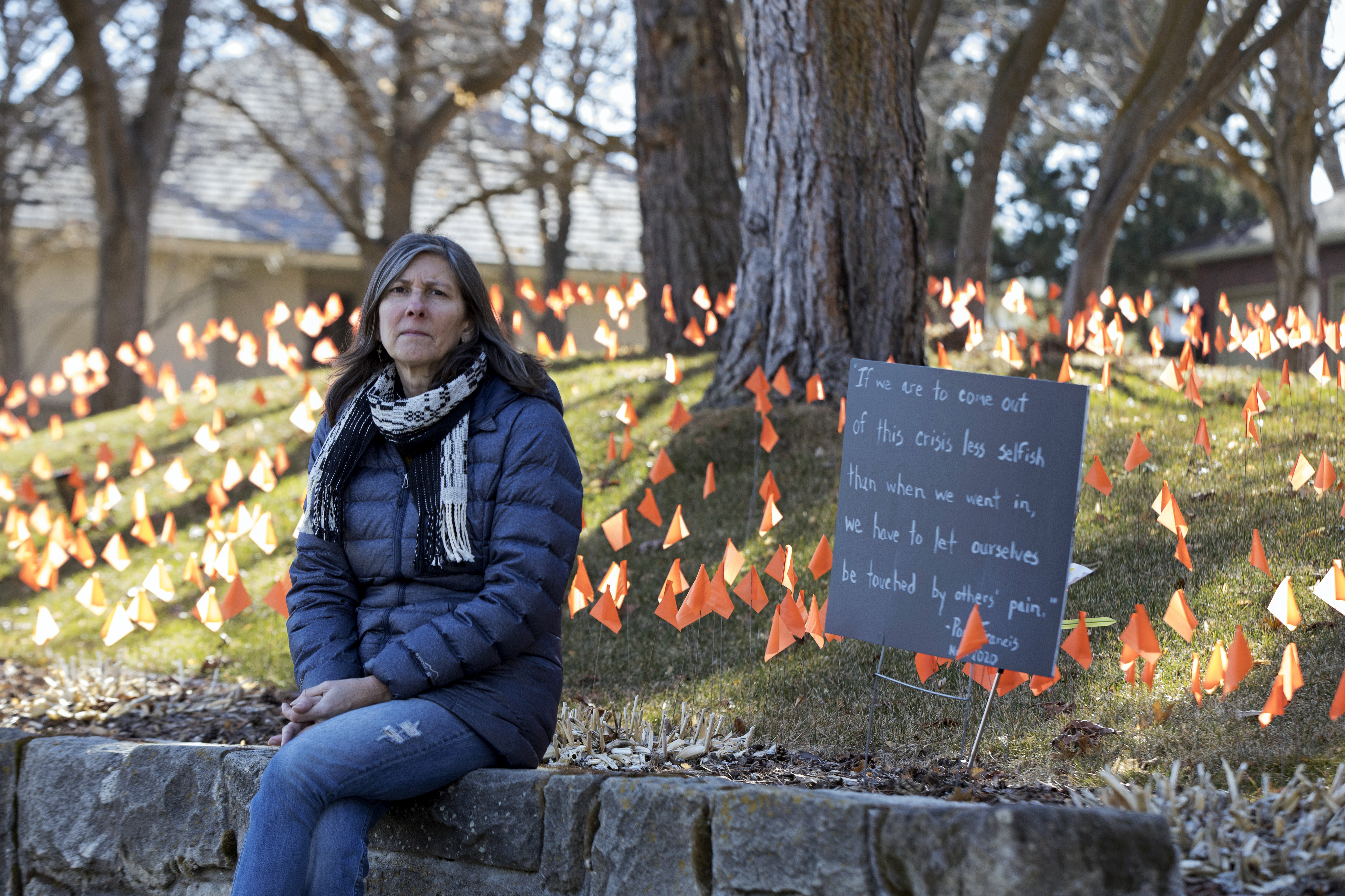 Cindy Pollock poses for a portrait in Boise, Idaho, on Wednesday, Feb. 10, 2021. Pollock began planting the tiny flags across her yard — one for each of the more than 1,800 Idahoans killed by COVID-19 — the toll was mostly a number. Until two women she had never met rang her doorbell in tears, seeking a place to mourn the husband and father they had just lost.