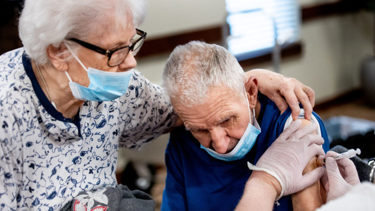 Lois Larsen, 83, comforts her husband, Jerry, 86, while he receives his second dose of the Pfizer-BioNTech COVID-19 vaccine at The Lodge at North Ogden on Thursday, Feb. 11, 2021.