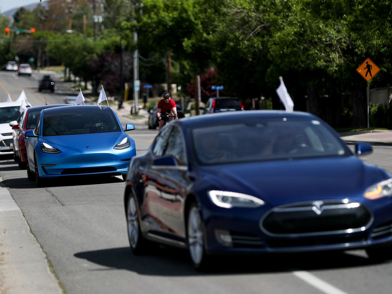 Teslas and other electric vehicles take off from the
Holladay City Office for an electric vehicle parade on Saturday,
May 16, 2020.