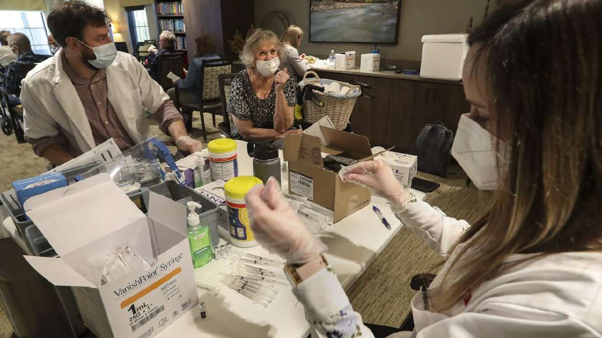 Cedarwood senior living community resident Yvonne
Bolingbroke, center, chats with Walgreens pharmacists Matthew
Sanders, left, and Mckayla Poulsen, right, before she received her
COVID-19 vaccination at Cedarwood in Sandy on Tuesday, Jan. 19,
2021. A Utah bill would prohibit employers from requiring employees
to get the COVID-19 vaccine, except those in health care settings
where a vaccine is required for their work.