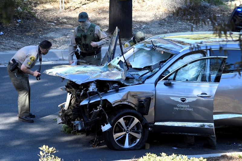 Los Angeles County Sheriff's Deputies inspect the vehicle of golfer Tiger Woods, who was rushed to hospital after suffering multiple injuries, after it was involved in a single-vehicle accident in Los Angeles, California, U.S. February 23, 2021. REUTERS/Gene Blevins