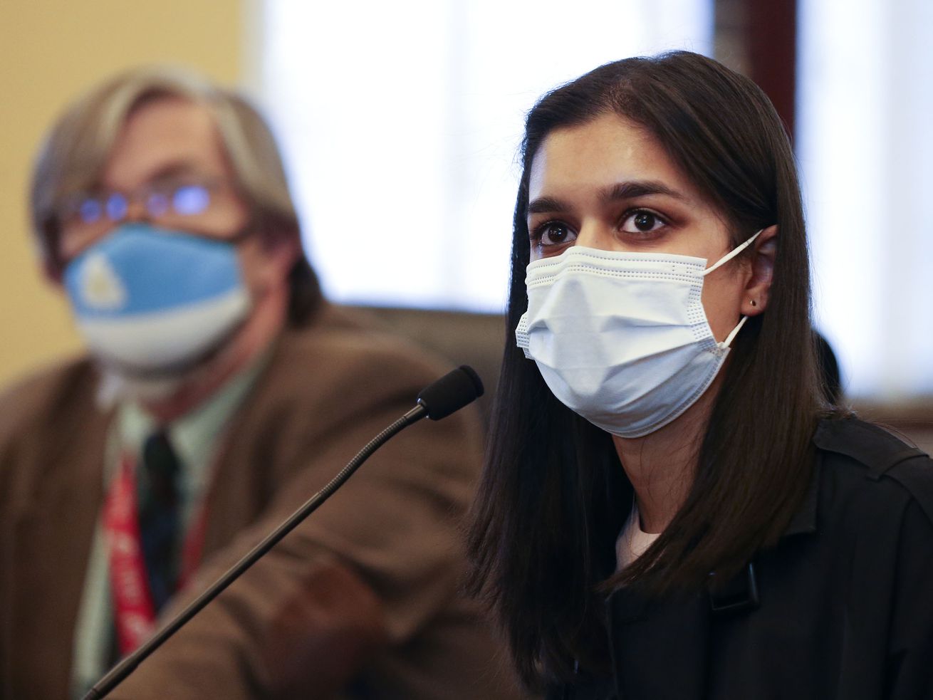 Rep. Joel Briscoe, D-Salt Lake City, left, listens as
Arundhati Oommen, a West High School student and student member of
the Salt Lake City Board of Education, center, testifies on HB338
at the Capitol in Salt Lake City on Wednesday, Feb. 24, 2021. The
bill, sponsored by Briscoe, would allow 16- and 17-year-olds to
vote in school board races — if permitted by the local school
board.
