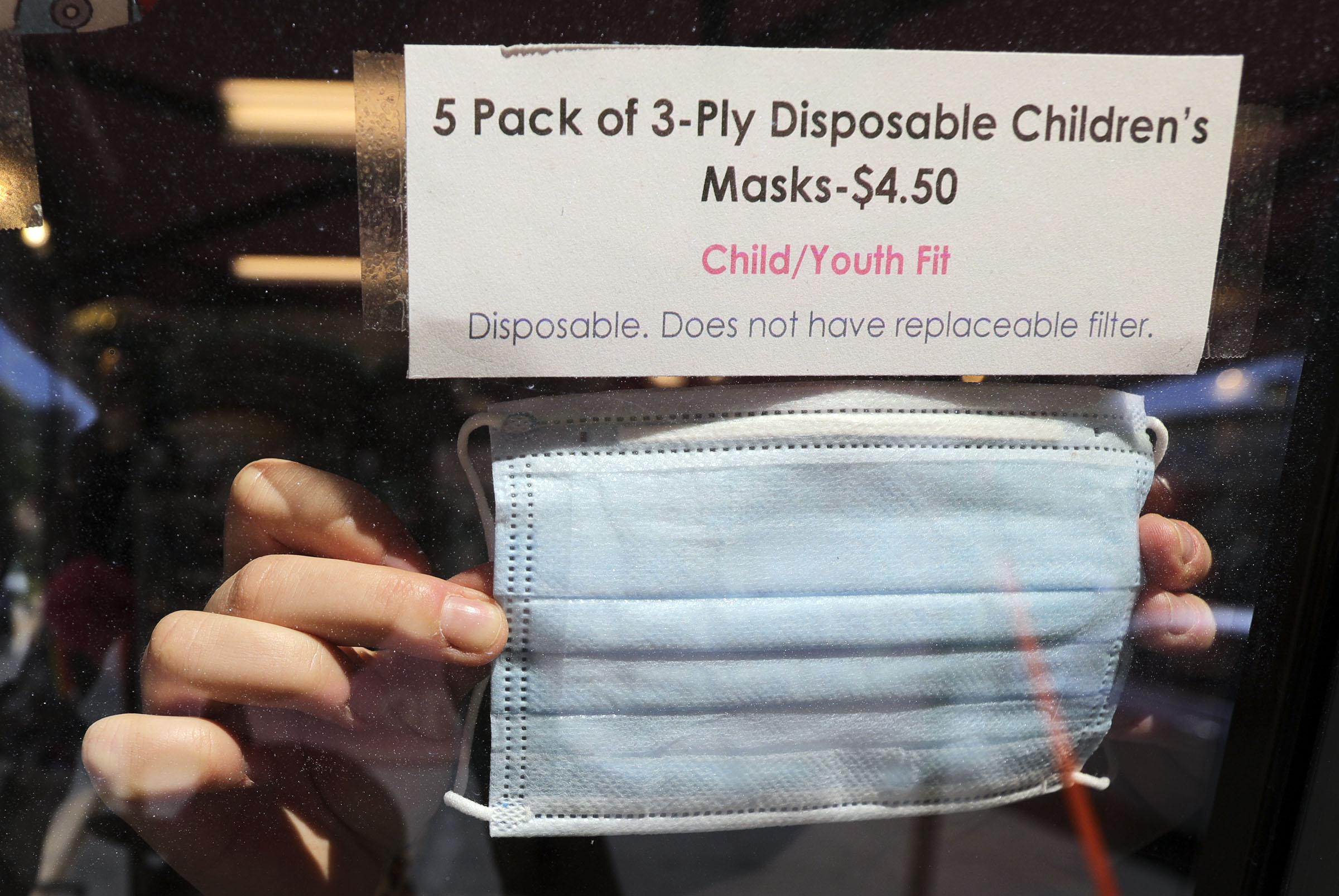 Fiona Spas rearranges a window display of face masks for sale at iconoCLAD in Salt Lake City on Friday, June 26, 2020. On Thursday, Gov. Gary Herbert approved requests from Salt Lake County and Summit County to require that masks be worn in public in those two counties.