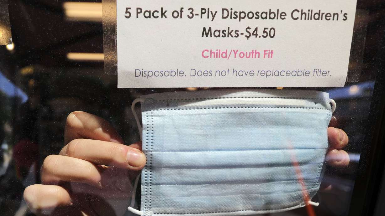 Fiona Spas rearranges a window display of face masks for sale at iconoCLAD in Salt Lake City on Friday, June 26, 2020. On Thursday, Gov. Gary Herbert approved requests from Salt Lake County and Summit County to require that masks be worn in public in those two counties.