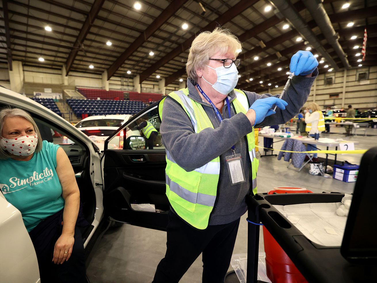 Pam Hammond, left, waits as Nena Saunders, with Davis
County Public Health, prepares a COVID-19 vaccination at a
drive-thru clinic at the Legacy Center Indoor Arena in Farmington
on Tuesday, Feb. 9, 2021.