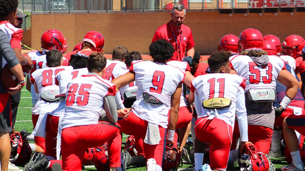 Dixie State football head coach Paul Peterson (center) addresses the team prior to the 2019 spring game in April.