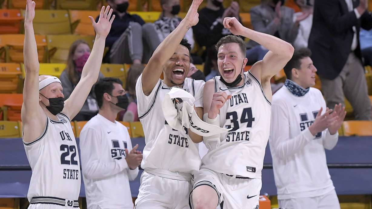 Utah State players celebrate on the bench after center Kuba Karwowski scored a point during the second half of an NCAA college basketball game against Nevada on Sunday, Feb. 28, 2021, in Logan, Utah. (Eli Lucero/The Herald Journal via AP, Pool)