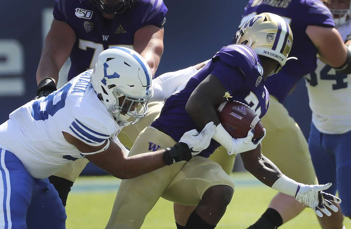 BYU defensive lineman Uriah Leiataua (58) face masks Washington running back Richard Newton (28)) in Provo on Saturday, Sept. 21, 2019.