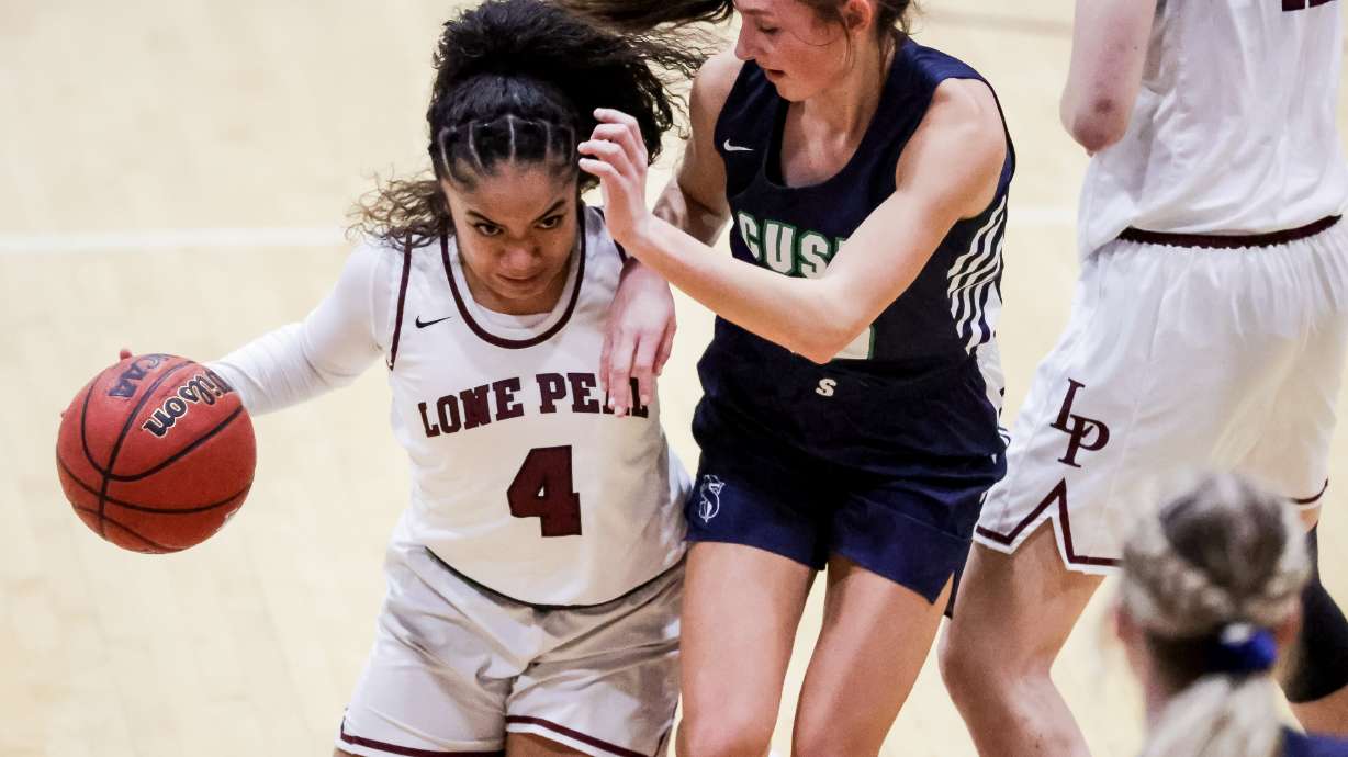 Lone Peak’s Makeili Ika drives against Syracuse’s Baylee Sanders in a 6A girls basketball quarterfinal game in Highland on Tuesday, March 2, 2021.