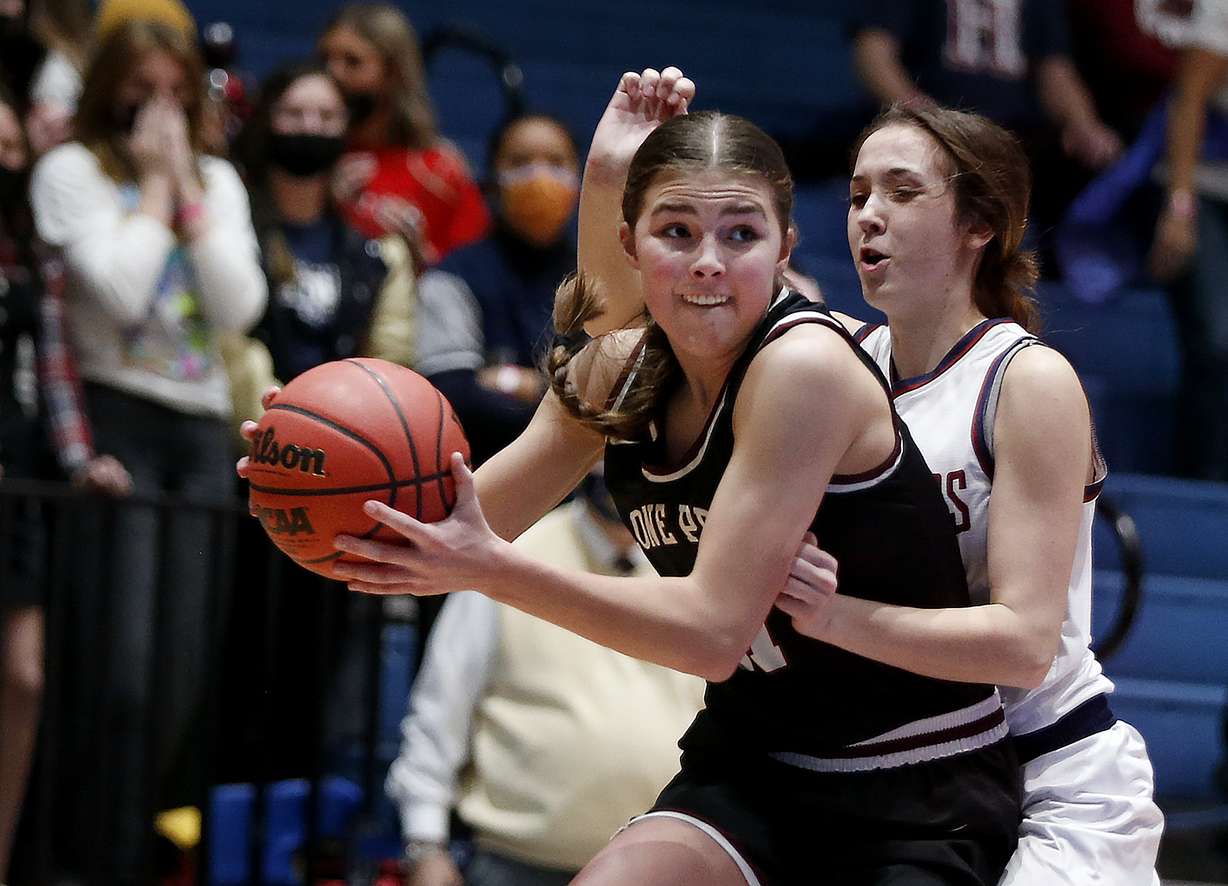 Lone Peak's Kailey Woolston (11) drives past Herriman's Mariah Mons (10) during a 6A girls basketball semifinal at Salt Lake Community College in Taylorsville on Thursday, March 4, 2021.