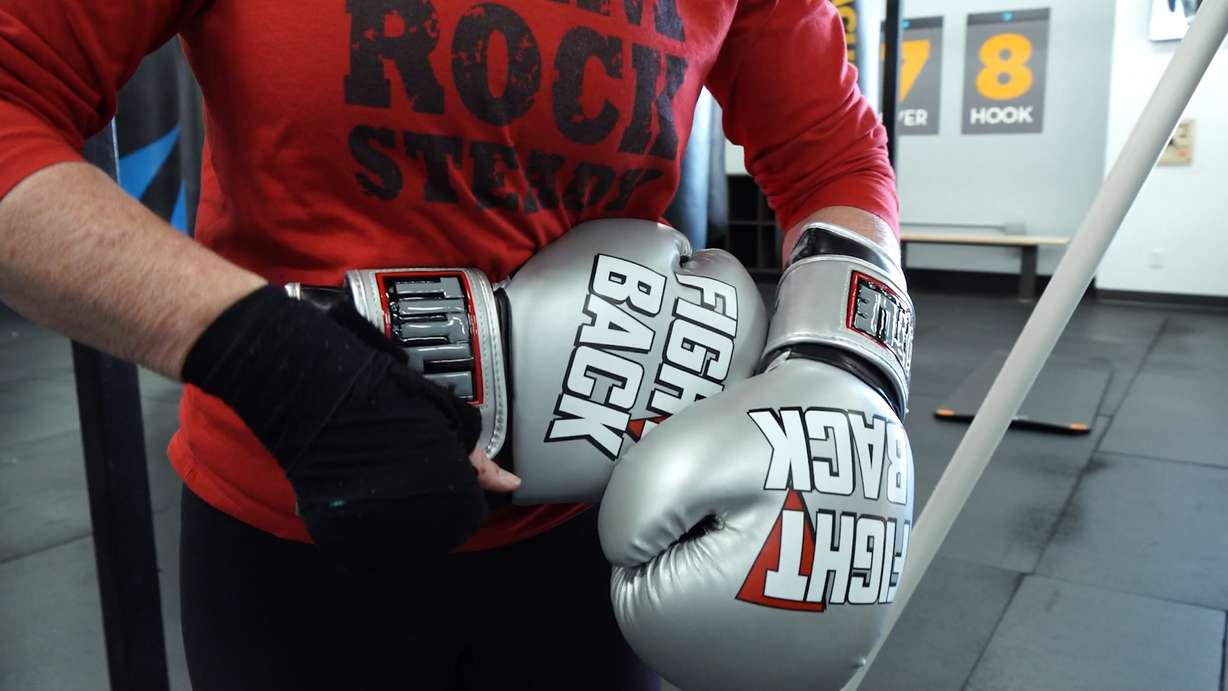 Jennifer Christ shows off her boxing gloves which read "Fight Back" on the outside and "Against Parkinson's" on the inside of the glove.