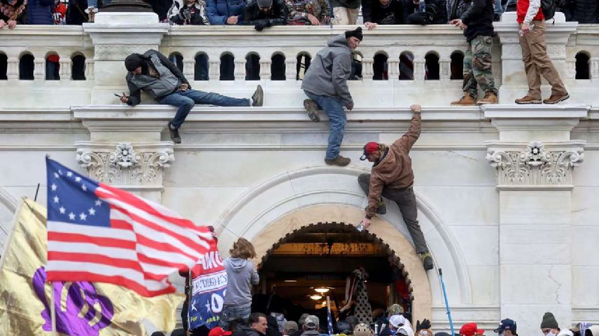 A mob of supporters of then-U.S. Pres. Donald Trump fight with members of law enforcement at a door they broke open as they storm the U.S. Capitol Building in Washington, U.S., January 6, 2021.