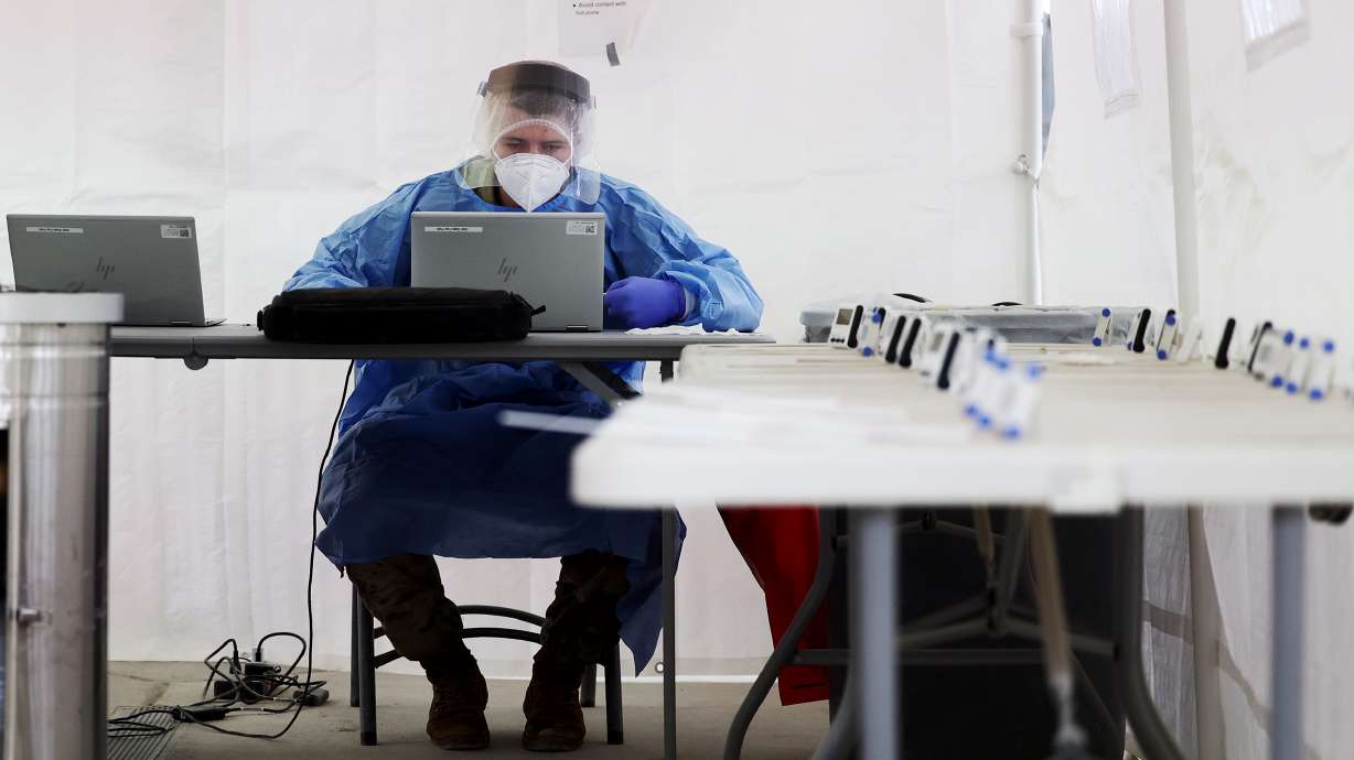 A National Guard worker works on a computer inside a results tent as residents receive their COVID-19 tests at the State Fair grounds in Salt Lake City on Friday, Feb. 26, 2021.