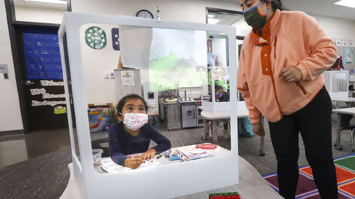 Edison Elementary School kindergartener Rebeca Prado
sits behind a protective screen as she works on English skills with
her teacher Veronica Hernandez at the school in Salt Lake City on
Monday, Nov. 23, 2020.